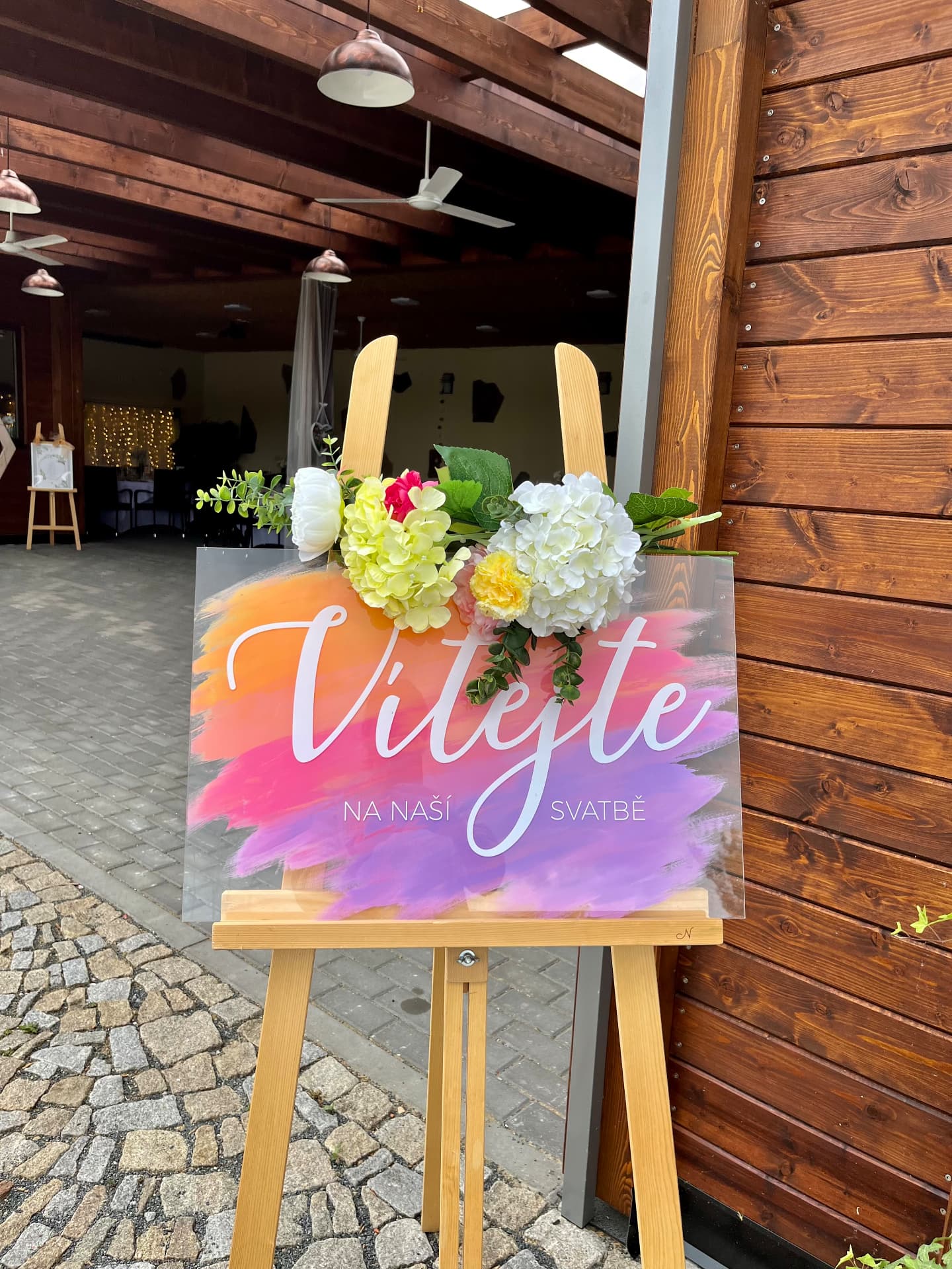 Vítací tabule na svatbě na dřevěném stojanu